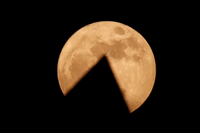 Moon rising behind the Lotus temple in in New Delhi, India. Image: Tsering Topgyal/AP
